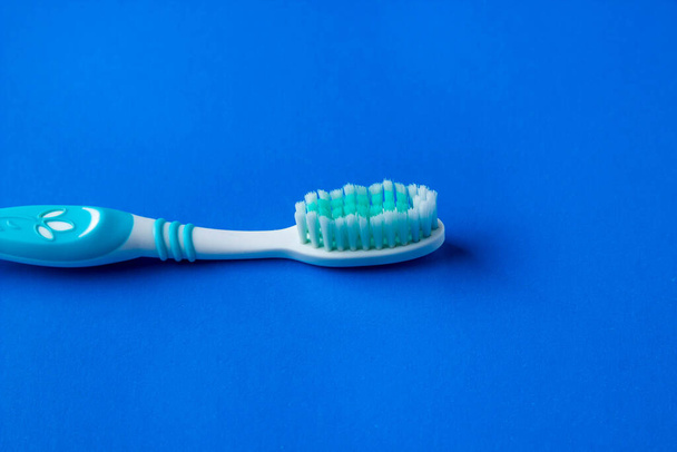 Mavi arka planda diş fırçası. Mavi diş fırçası. Oral sağlık kavramı - Fotoğraf, Görsel
