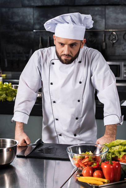 Chef male at kitchen restaurant. Portrait of serious male cooker in uniform. - Photo, Image