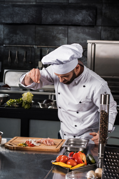 Chef salt slice vegetables and meat. Concentrated chef prepare food. - 写真・画像