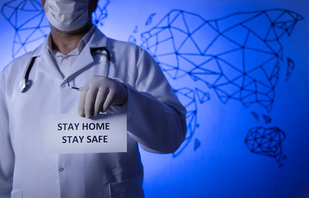 Un médico con un papel con una estancia en casa sosteniendo la mano, protegiéndola del Coronavirus o de la epidemia de Covid-19. - Foto, imagen