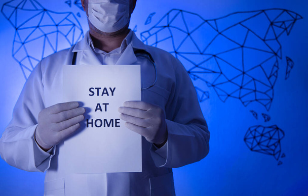 Врач с бумагой, который сидит дома, держа под рукой, защищает от коронавируса или эпидемии Ковид-19. - Фото, изображение