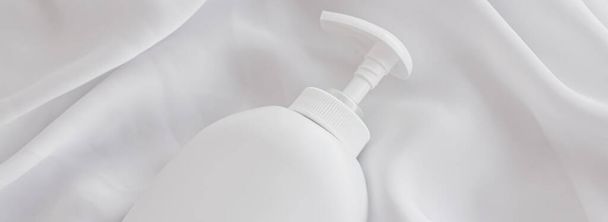 Prázdný štítek kosmetický obal láhev jako výrobek mokup na bílém hedvábí pozadí - Fotografie, Obrázek