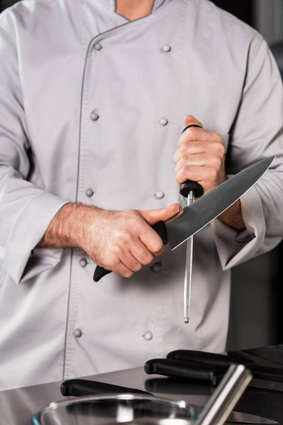 Σεφ χέρια με μαχαίρι στο εστιατόριο της κουζίνας. Κοντινό πλάνο χέρια σεφ με μαχαίρι. - Φωτογραφία, εικόνα