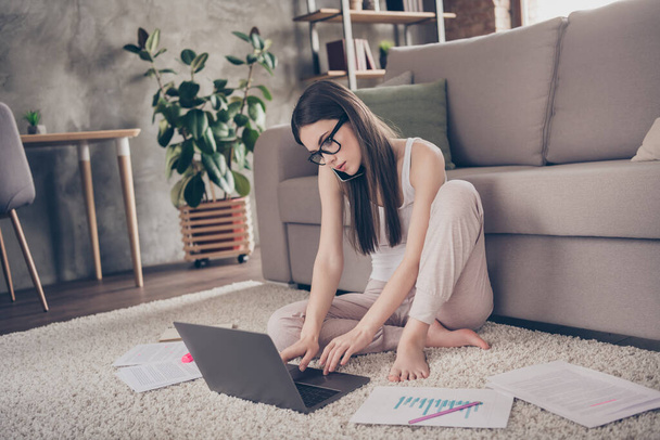 Full body photo of focused girl manager marketer work distance laptop typing chatting have problem call smartphone speak tell talk say colleagues executive sit carpet in house indoors - Фото, зображення