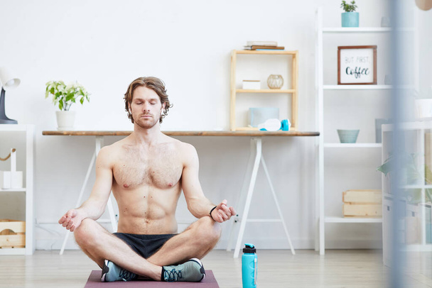 Homem saudável meditando em casa
 - Foto, Imagem