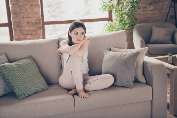 Full length photo of frustrated upset miserable girl sit comfort cozy couch look think future coronavirus covid-19 quarantine in apartment living room indoors - Photo, Image