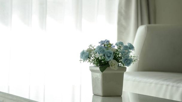vaso de cerâmica branca com flor de plástico na sala
 - Foto, Imagem