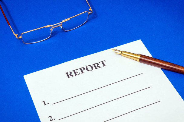 Formulário de relatório na mesa azul do escritório com óculos e caneta, ideia de negócio
 - Foto, Imagem