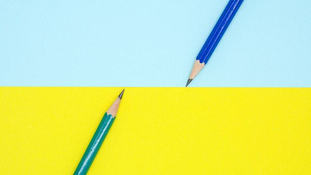 kék és zöld ceruza kék és sárga papíron - háttér - Fotó, kép