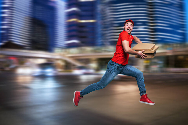 Corriere corre veloce per consegnare rapidamente pizze. Sfondo ciano
 - Foto, immagini