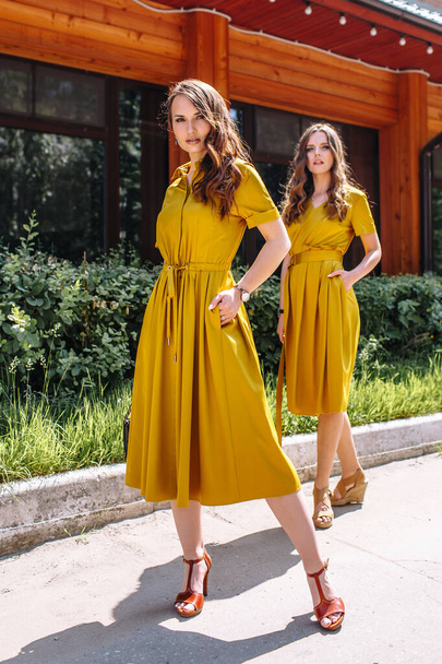 Two models in mustard colored dresses - Photo, image
