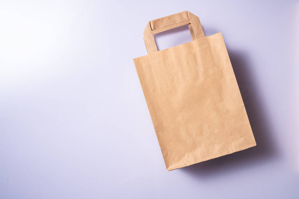 Shopping paper bag. Concept of consumerism, shopping symbol. Copy space trend pastel color. - Foto, Bild
