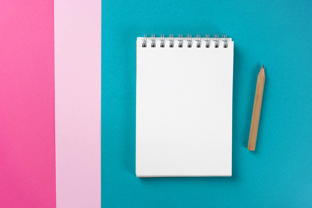 Notebook on trendy turquoise, pink, magenta paper colorful background. Workspace, study concept. Mock up, copy space, top view, flat lay. - Φωτογραφία, εικόνα
