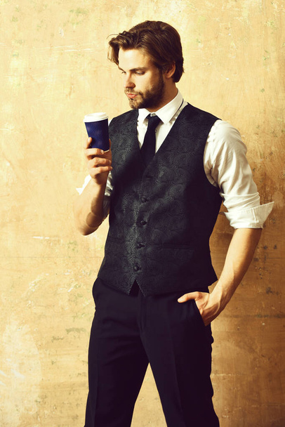 morning coffee, young serious business man holding paper cup - Zdjęcie, obraz