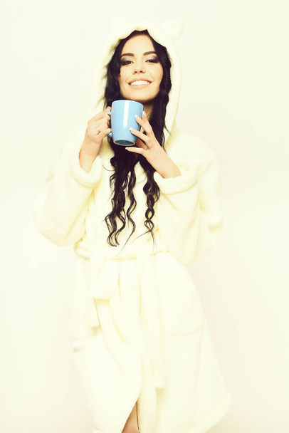 smiling sexy girl posing in beige velour bathrobe with cup - Fotoğraf, Görsel