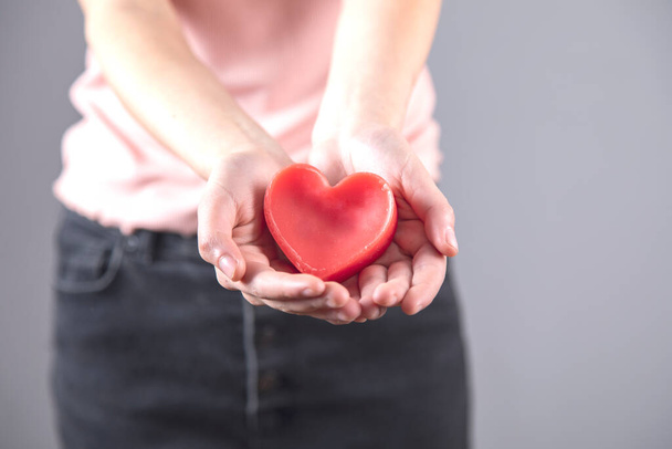 woman hand red heart on the grey background - Zdjęcie, obraz