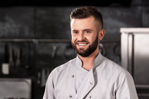 Chef at kitchen restaurant. Portrait of smiling chef at professional kitchen. - Foto, Imagen