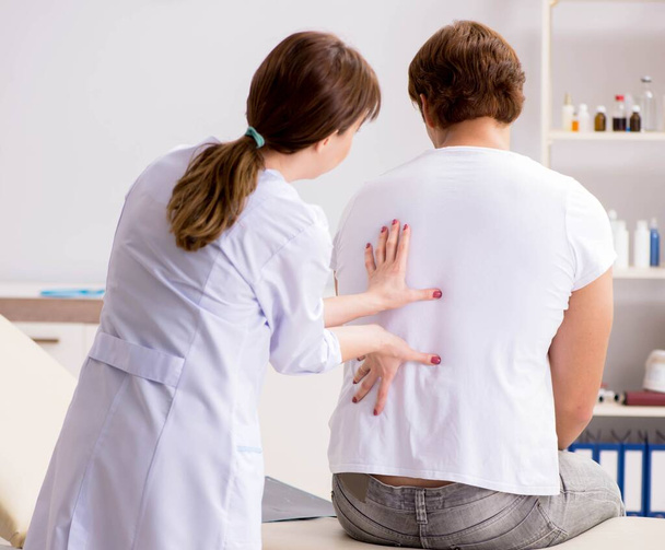 Пациент-мужчина посещает молодую женщину-врача-хиропрактика
 - Фото, изображение