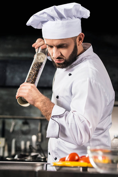 Chef with pepperbox at kitchen restaurant. Portrait of chef with pepperbox. - Foto, afbeelding