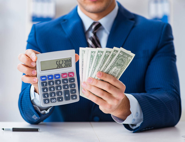 Бухгалтер рассчитывает доллары с помощью калькулятора в офисе - Фото, изображение