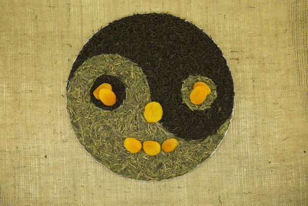 El concepto de yin yang. Firme yin yang contra el fondo de la arpillera. Se utilizó té verde chino Lundzyn, té negro indio y limón.
. - Foto, imagen