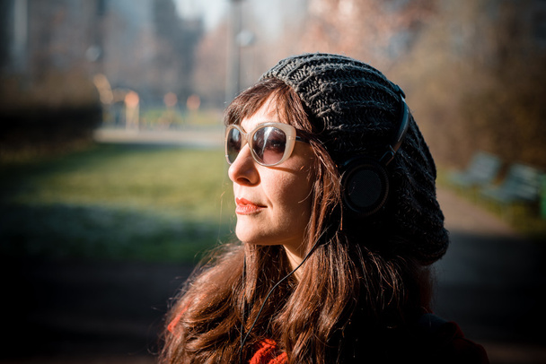 красивая женщина в красном пальто слушает музыку
 - Фото, изображение