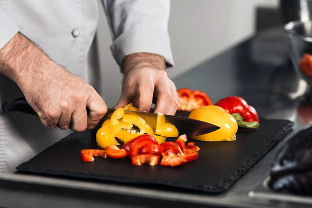 Chef hands cook food at kitchen restaurant. Closeup chef hands slice pepper. - Foto, afbeelding