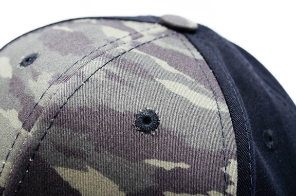Men's two-tone cap on a white background. The baseball cap is black at the back, front and visor of the military workshop, khaki camouflage. Men's black cap with camouflage in macro. Side view, stern, top. Cap closure, button on top, ventilation hole - Photo, Image