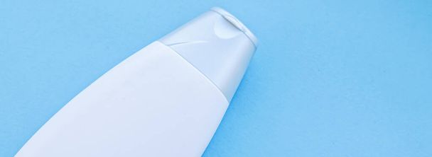 Blank label cosmetic container bottle as product mockup on blue background - Zdjęcie, obraz