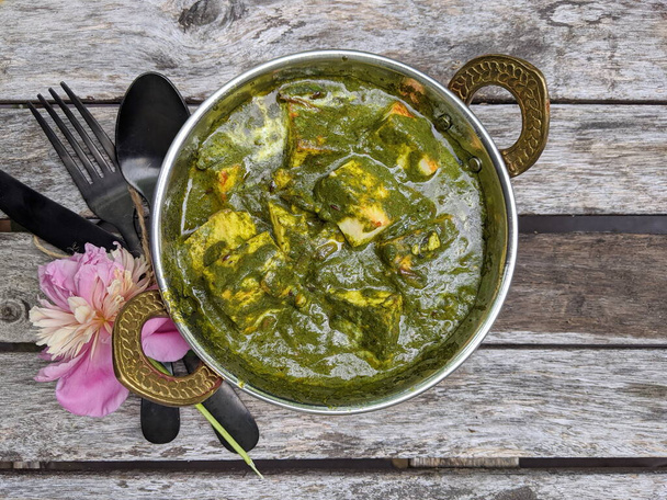 A bowl of Palak Paneer made of Paneer cheese dipped in mildly spiced Spinach gravy on wooden background. - Photo, Image