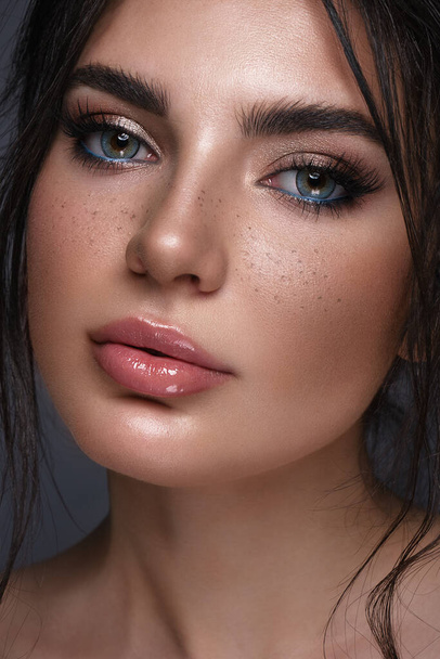 Beautiful girl with bright fashionable make-up, freckles and blue eyes. Beauty face. - Photo, Image