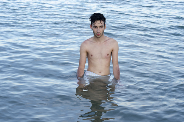 Красивый молодой человек в купальнике отдыхает в море во время летних каникул
 - Фото, изображение
