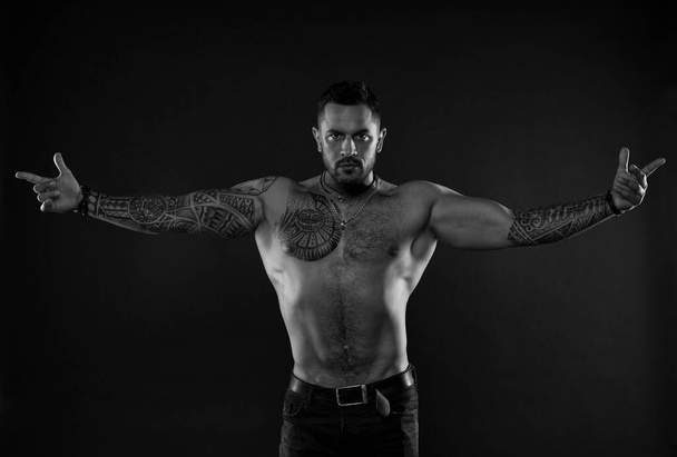 Here I am. Bearded man with tattooed torso. Macho sexy bare torso. Fit model with tattoo art on skin. Sportsman or athlete with stylish beard and hair. Sport and fitness. Masculinity. Muscular torso - Foto, Imagen