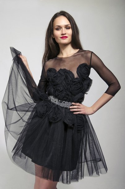 Beautiful brunette woman wearing a black dress and dancing - Valokuva, kuva