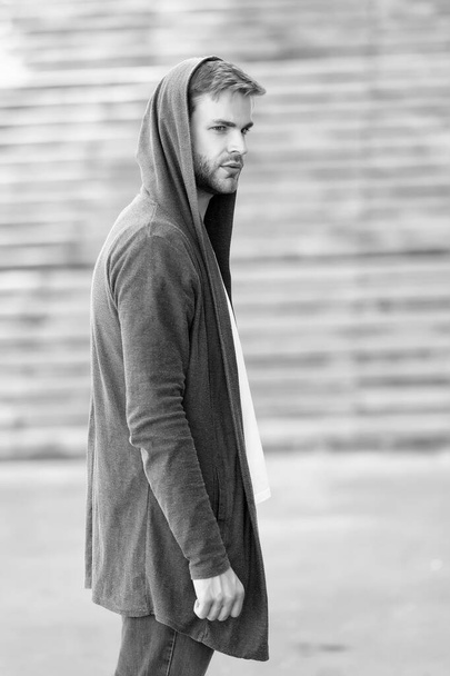 informal style clothing. Fashionable young model man. Mystery man posing with hoodie. young street man with hood. Incognito Boy. handsome man with hood standing in urban city interior. Cool and sexy - Φωτογραφία, εικόνα