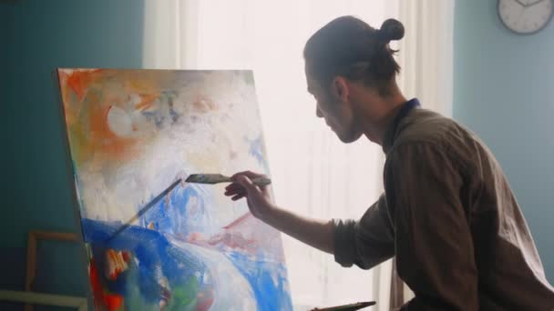 若い男は家で絵を描いている - 映像、動画