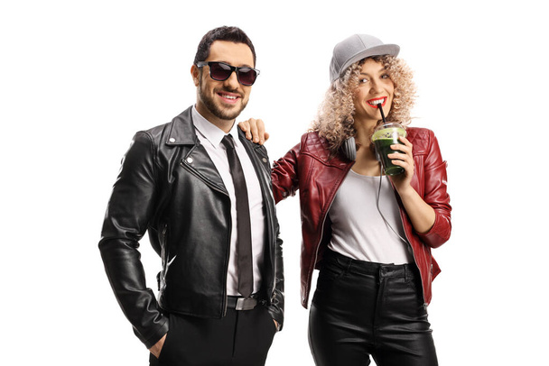 Trendy man with sunglasses and a blond woman in leather jackets with a green smoothie isolated on white background - Φωτογραφία, εικόνα