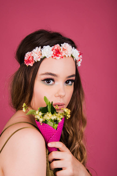 Portret van jonge vrouw, mooie tiener model hoofd schot met lang haar en moderne make-up, stijlvolle mode look geïsoleerd op roze achtergrond, pastel kleur schema stijl - Foto, afbeelding
