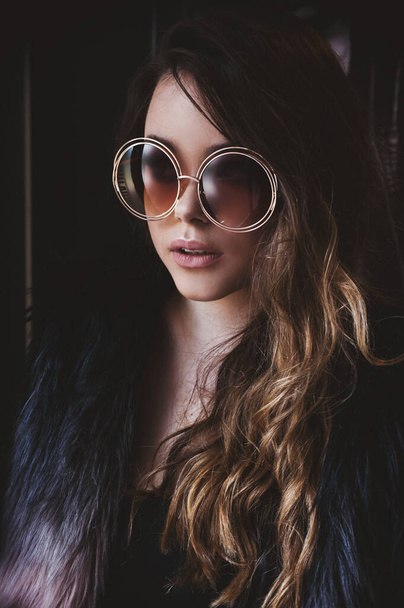Porträt eines schönen Modells mit Großaufnahme-Brille. Modische Sonnenbrille, moderner, trendiger Stil, sanfte beige Farben  - Foto, Bild