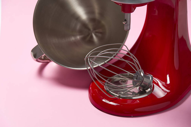 Stijlvolle rode keukenmixer met clippad geïsoleerd op roze achtergrond. Professionele stalen elektrische mixer met Metal Whisk - Foto, afbeelding