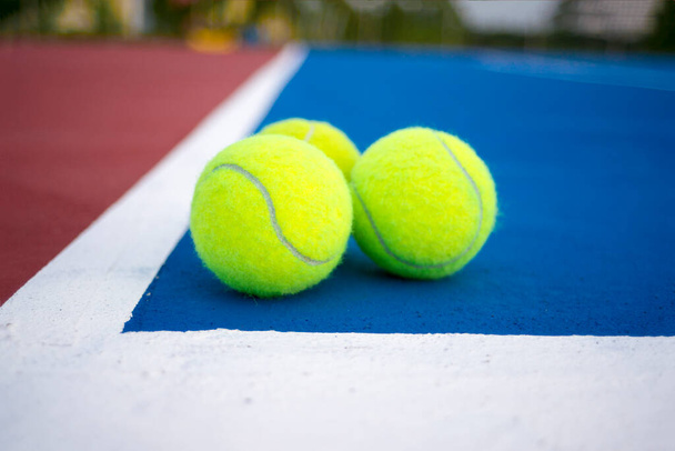 Old three tennis balls on tennis court. - 写真・画像
