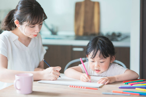 Mutter und Tochter zeichnen zu Hause am Esstisch - Foto, Bild