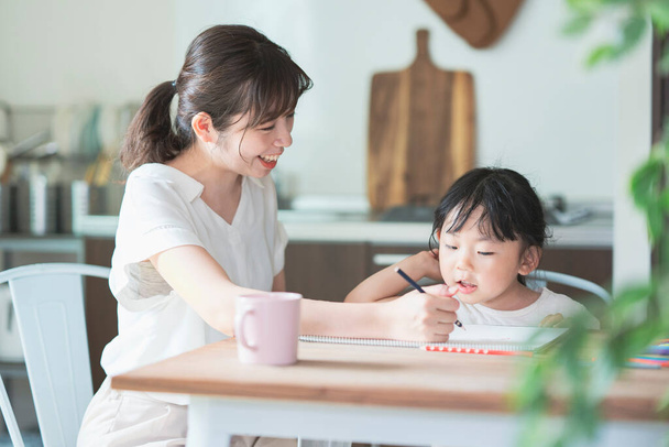 Mutter und Tochter zeichnen zu Hause am Esstisch - Foto, Bild