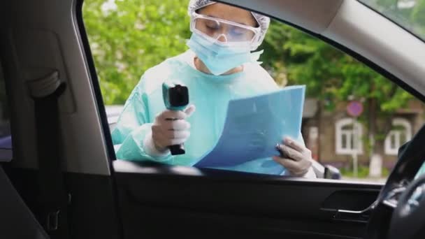 Doctor mujer utilizar pistola de termómetro infrarrojo para comprobar la temperatura corporal - Metraje, vídeo