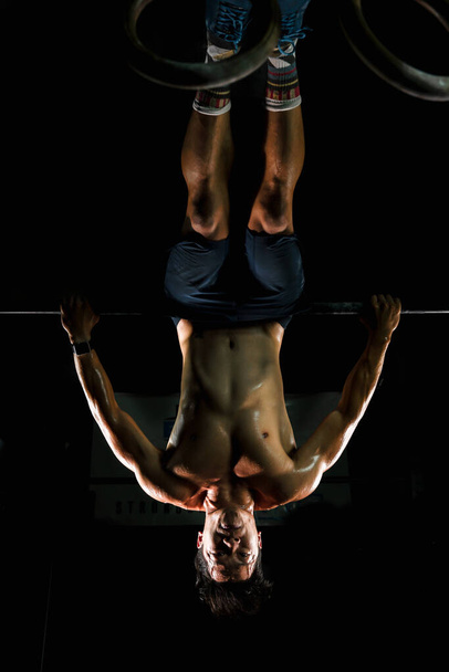 asian athletics man training gymnastics exercise on nhigh bar in gym and fitness club - Fotó, kép