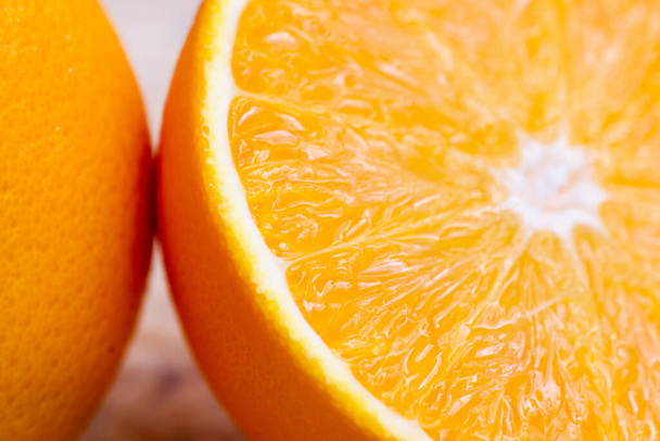 Slice of fresh orange on wooden plate, Selective focus - 写真・画像