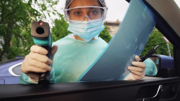 Doctor mujer utilizar pistola de termómetro infrarrojo para comprobar la temperatura corporal - Metraje, vídeo