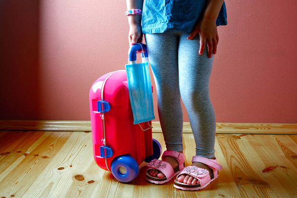 Little cute kid girl in quarantine at home dreams of traveling. - Valokuva, kuva