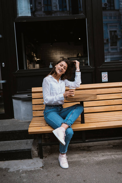 Bella giovane donna in caffè di strada beve caffè - Foto, immagini