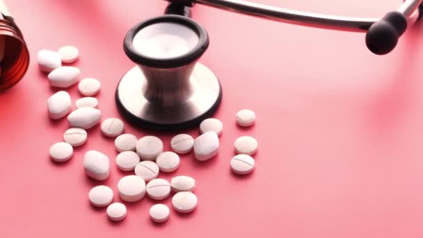 pills, stethoscope and container on pink background  - Footage, Video